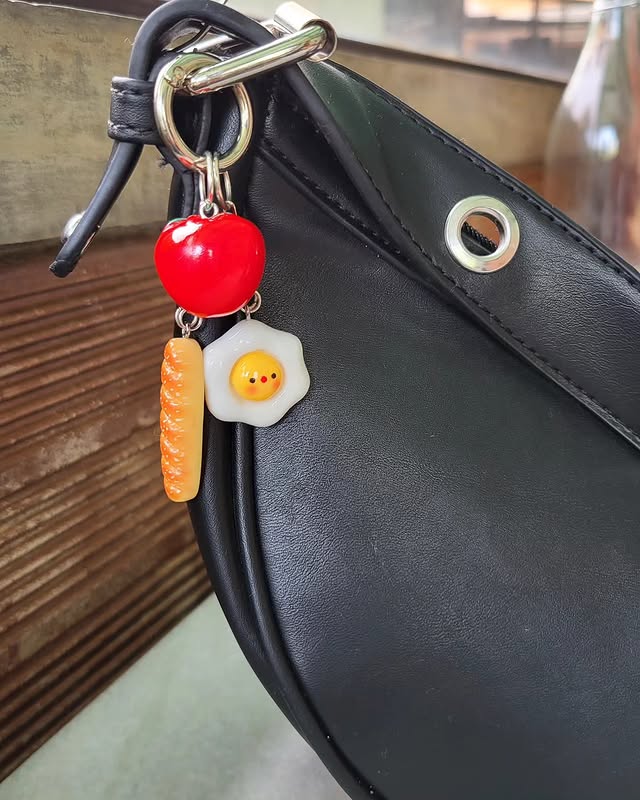 Keychain charm clipped to a black bag
